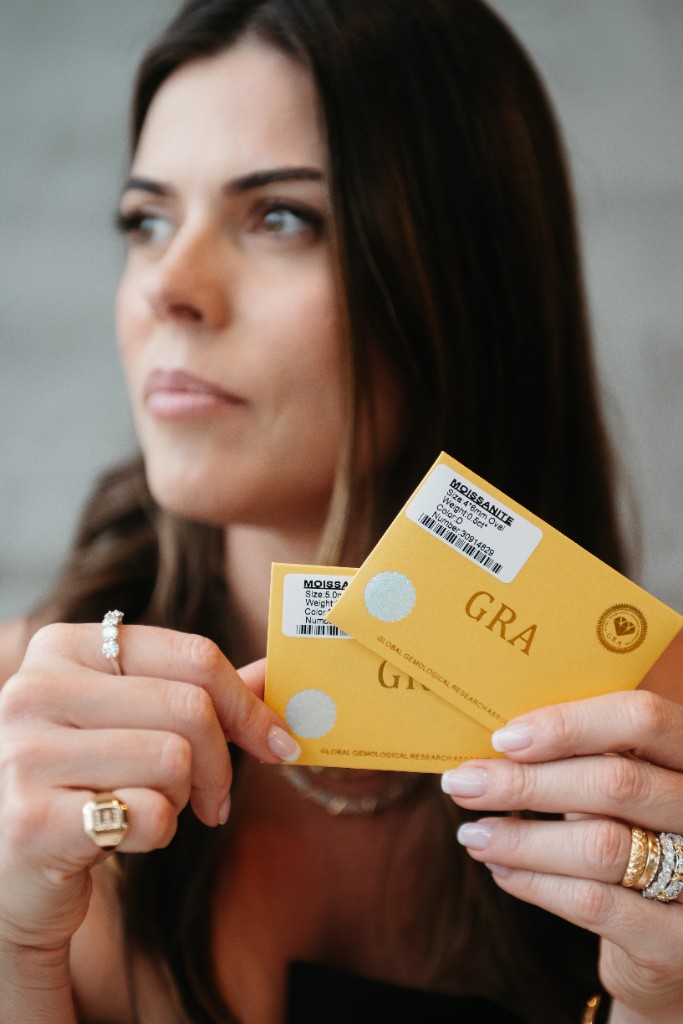 A Lise segurando certificados GRA de moissanite